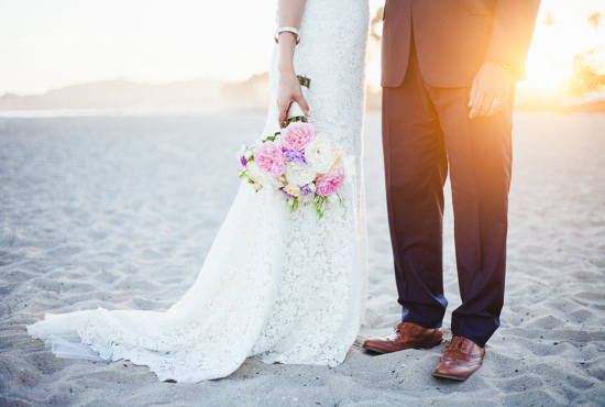 Bride and groom with wedding bouquet at sunset on the beach in Santa Barbara, California